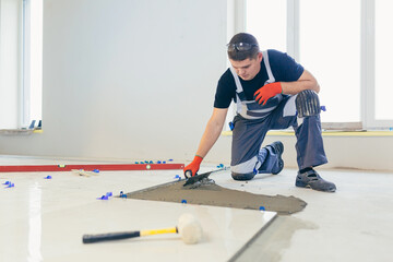 A male construction worker installs a large ceramic tile