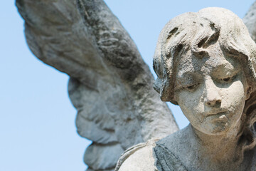 Beautiful angel as symbol of death and the end of human life. Fragment of an antique stone statue.