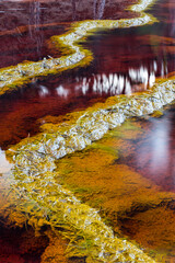 Stones in red waters connected by stromatolites, Rio Tinto river, Andalusia Spain.