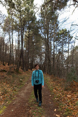 Young sporty female hiking up from a valley to the top of a mountain. Athletic young woman walking in the countryside during the winter in Spain.
