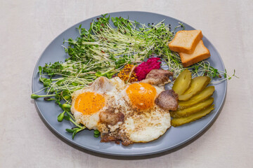 scrambled eggs with bacon, micro green, mustard and pickled cucumber