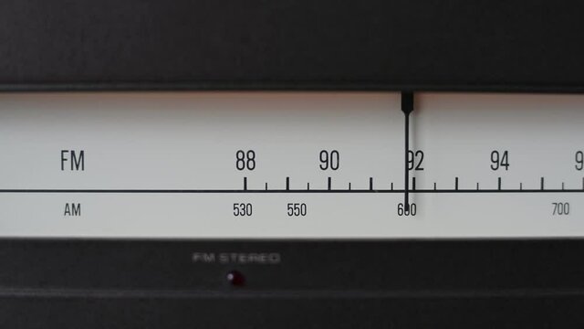 Turning retro radio by hand. Band tuning of old classic radio receiver. Close up