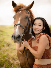 Obraz premium Portrait of Asian woman and brown horse. Woman hugging horse. Romantic concept. Love to animals. Nature concept. Bali, Indonesia