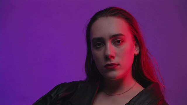 Footage of sitting woman in room with red and blue light