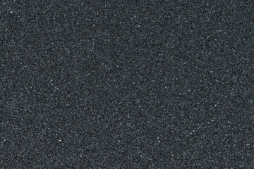 Full frame of black sandpaper texture. Abrasive material with a gritty surface