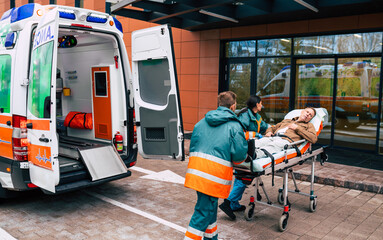 Serious and professional team of doctors in the ambulance moving on a patient into the hospital...