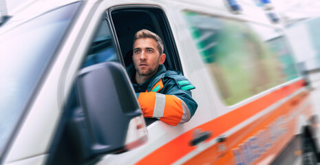 Professional and confident young man doctor looking on the camera with ambulance background © My Ocean studio