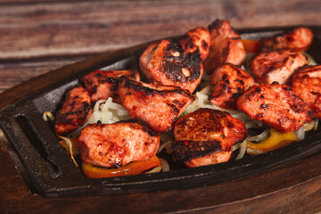 Close up of tandoori chicken, indian spicy food on wooden background