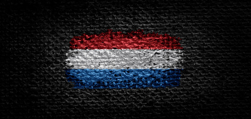 National flag of the Netherlands on dark fabric