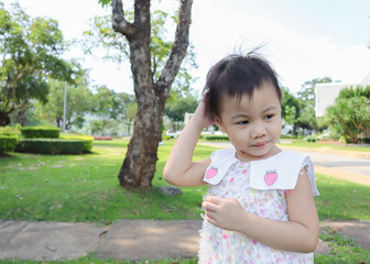 3 years old Asian little girl scratching her head.