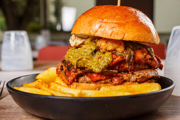 Panino da pub con parmigiana di melanzane, pesto di basilico, provola affumicata e hamburger di...