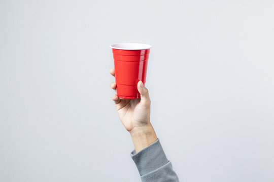 Hand raising the red cup, Copy space.