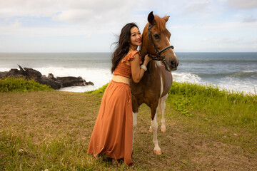 Obraz premium Woman hugging brown horse. Romantic concept. Love to animals. Nature concept. Bali