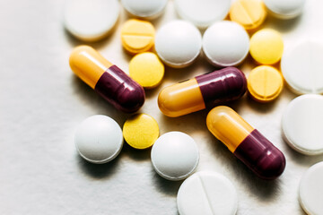 A rash of pills of brown-yellow and white, yellow tablets close-up top view. Background. Medicines. Medical background. Antibiotics