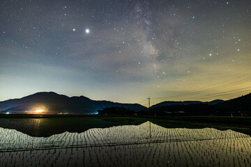 田植え時期の水田と星空