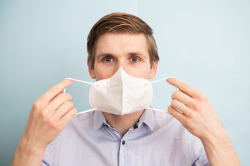 Man wearing FFP2 and KN95 face mask while standing against blue background. Time to upgrade masks...