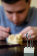 Dental technician modelling tooth crowns with hot wax. Workplace of a dental technician.