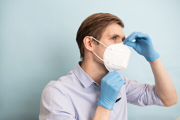 Man wearing FFP2 and KN95 face mask while standing against blue background. Time to upgrade masks...