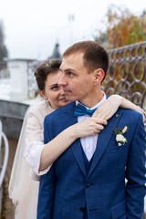 two newlyweds on a wedding walk in winter, lovers happily hug and gently kiss, two adults on a date