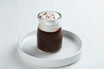 Chocolate pudding with whipped cream and chocolate as  topping  in portion glasses