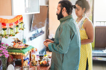 Indian husband and wife celebrating hindu festival at home - Focus on man face