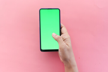 top view of women hand using smart phone on pink 
