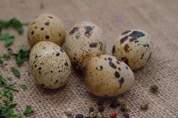 Fototapeta premium Fresh quail eggs with spices on burlap. Space for text