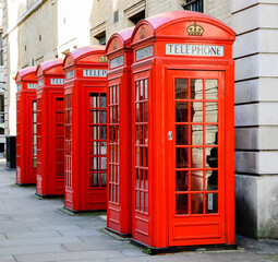 Five traditional old style red phone boxes in London, UK.
