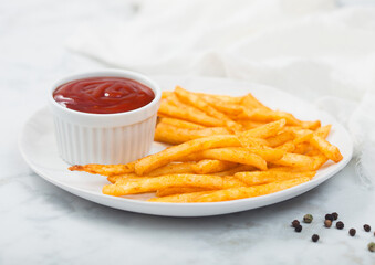 French fries chips with tomato ketchup in white plate on white marble background with white cloth