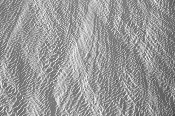 Background with the texture of travertine's surface (channels of shadows on the light calcium carbonate). Black and white version.