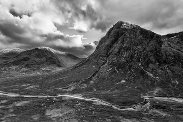Flying drone epic  black and white landscape image of Buachaille Etive Mor and surrounding mountains and valleys in Scottish Highlands on a Winter day