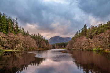 Stunning landscape image of Glencoe Lochan with Pap of Glencoe in the distance on a Winter's evening