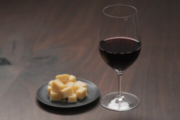 glass of red wine with vintage cheese on small plate