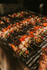 shrimp and vegetable skewers on a black grill.