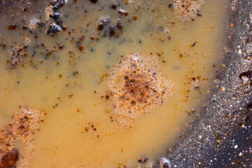Burned oily leftover grease fat in a pan macro shot air bubbles top view