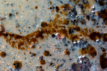 Burned oily leftover grease fat in a pan macro shot air bubbles top view