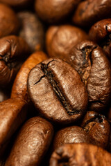 Brown roasted coffee bean macro close up shot isolated small pile of beans in the background