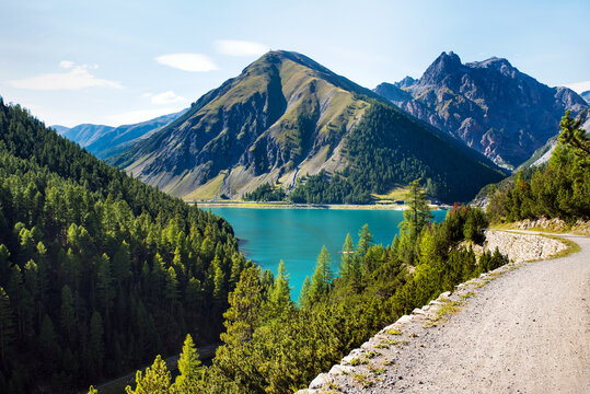 hiking trail leading to Lake Alpisella in the background beautiful Lake Livigno in the Lombardy region.