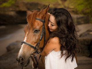 Fototapeta premium Portrait of Asian woman and brown horse. Woman hugging horse. Romantic concept. Love to animals. Nature concept. Bali