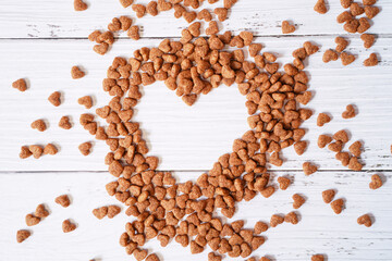 Top view of heart shape space made from heart shape dog food  on white wooden background for Valentine , love and dog lover concept