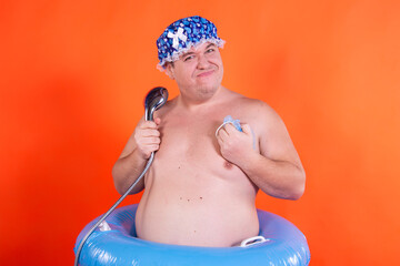 Funny fat man is washing in the shower.
