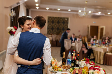 the bride and groom kiss in a restaurant, the happiness of the newlyweds at the wedding ceremony, a romantic kiss