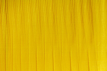 Yellow background made of crumpled corrugated kraft paper. Yellow paper folded up.