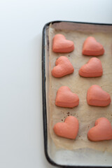 homemade pink shortbread cookies for valentine's day on a baking sheet.