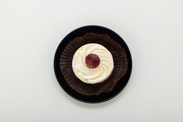 Cake basket with cream and raspberries, on paper on a light background
