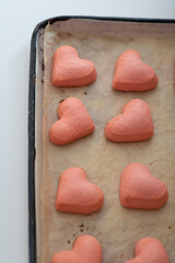 homemade pink shortbread cookies for valentine's day on a baking sheet.