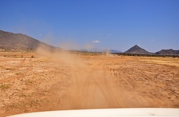 Widok bezdroży z tyłu jadącego samochodu, pył i kurz (Kenia)