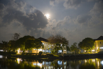 Fototapeta premium One of the buildings was lit up at night and there was a bright moon in the sky.