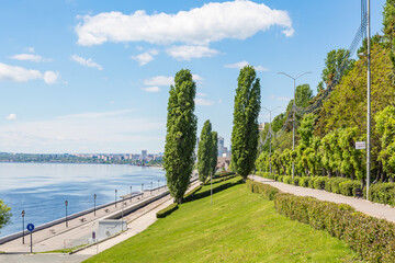 A deserted embankment on a spring or summer day. Clouds in a blue sky. The Volga River in the background, the city of Saratov, Russia