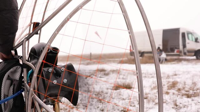 Close up of man hands starts to work a propeller, motor, engine of the paramotor paraglider
